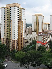 Bangunan bertingkat tinggi berdiri berjajar satu sama lain dipinggir jalan. Sebuah unit blok apartemen di sebelah kanan disorot dengan warna mereka.