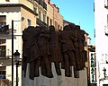 Monumento a los Abogados de Atocha (2003), basado en la obra pictórica El Abrazo, de Juan Genovés (1976), que había sido utilizada como cartel de la Junta Democrática en favor de la amnistía, a consecuencia de lo cual el autor fue detenido.[85]​