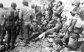 Amerikanske soldater på Omaha-stranden, under kalkklippene, noen sårede (stor versjon)