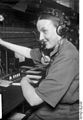 Das Bild zeigt eine Telefonistin mit Headset und Mikrofon im Jahr 1930 bei der Arbeit