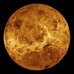 Venus in approximately true colour, a nearly uniform pale cream, although the image has been processed to bring out details.[1] The planet's disc is about three-quarters illuminated. Almost no variation or detail can be seen in the clouds.