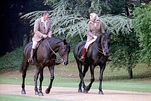 Elizabeth dan Ronald Reagan menaiki kuda hitam.
