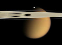 Měsíc Titan za prstenci Saturnu