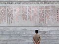 Bir Kuzey Kore yurttaşı kuledeki Kim İl-sung'e atfen yazılmış şiiri okuyor, 2012