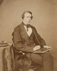 Sepia toned three-quarter-length portrait of a seated man