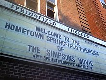 Un conseil d'administration se lit comme suit "Bienvenue à la Première Originaire de Springfield de The Simpsons Movie".