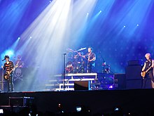 Una fotografia a colori dei membri dei Green Day in concerto