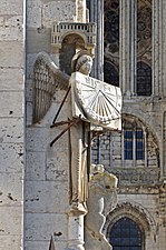 L'ange au cadran, à l'angle du clocher de la Cathédrale Notre-Dame - Chartres, Eure-et-Loir (France). L'ange qui présente ainsi son cadran au sud est une copie datant de 1974, l'original de 1528 se trouve dans la crypte.
