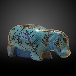 Un hipopotam decorat cu plante acvatice, realizat din faianță cu o glazură albastră. (2033–1710 î.Hr.)