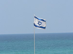’n Israeliese vlag voor die agtergrond van die Middellandse See