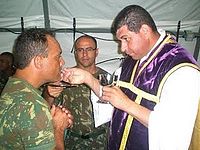 O Capitão Capelão João Batista entrega a comunhão para militares no Haiti.