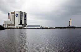 Zwaaikom bij het Kennedy Space Center. Op de achtergrond wordt de space shuttle Columbia naar buiten gerold.
