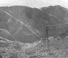 Photographie argentique noir et blanc représentant le téléphérique de Massaoua à travers les montagnes érythréennes.