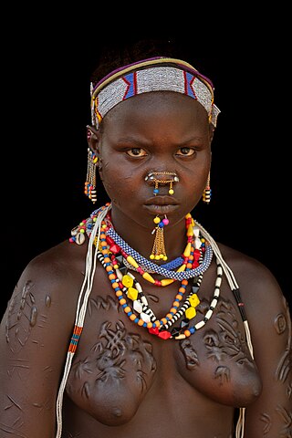 Young Laarim woman with extensive scarification, Kimotong, South Sudan.NSFWTAG