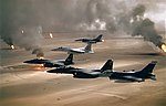 Amerikanska stridsflygplan flyger över brinnande oljekällor i Kuwait under Kuwaitkriget i samband med att de irakiska ockupationsstyrkorna retirerar.