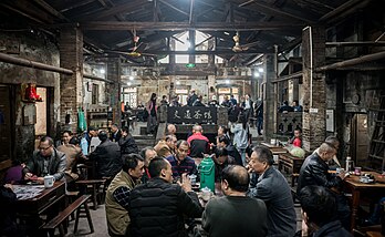Casa de chá Jiaotong em Xunquim, China. Por apenas dez iuanes, pode-se passar um dia inteiro tomando uma xícara de chá e conversando com amigos, jogando xadrez ou cartas. Uma casa de chá (principalmente na Ásia) ou sala de chá é um estabelecimento que serve principalmente chá e outras bebidas leves. Uma sala de chá pode ser uma sala reservada em um hotel, especialmente para servir o chá da tarde, ou pode ser um estabelecimento que serve apenas o tradicional ritual britânico que combina chá e o scone. Embora a função de um salão de chá possa variar de acordo com a circunstância ou o país, as casas de chá costumam servir como centros de interação social, como as cafeterias. (definição 7 352 × 4 523)