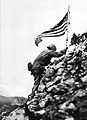 US Flag raised over Shuri castle on Okinawa. Braving Japanese sniper fire, US Marine Lieutenant Colonel R.P. Ross, Jr. places on American flag on a parapet of Shuri castle on May 29, 1945