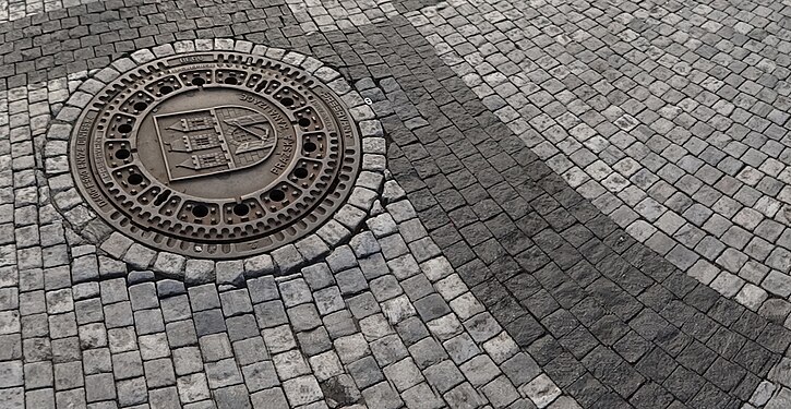 Manhole cover on a cobblestone street in Prague, the Czech Republic
