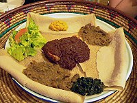 Hidangan yang umum ditemui di Etiopia dan Eritrea: Injera (roti tipis menyerupai panekuk) dan berbagai jenis wat (rebusan)