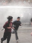 Manifestantes huyendo de un carro lanza-agua en los disturbios del 1 de junio de 2006.