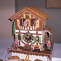 A gingerbread house with clock and candy decorations