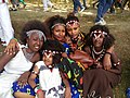 This photo represents the varieties of dressing and hairstyle of the Oromo culture. the kid sitting in front of the group dressed Guji Oromo clothes. the four girls at the back from left to right, dressed Harar, Kamise, Borena and Showa styles and all are Oromo style