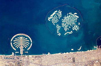 جُزر اصطناعيَّة في مياه الخليج العربي في إمارة دبي، بالإمارات. تظهر نخلة الجُميرة في أدنى اليسار، وجُزر العالم في أعلى اليمين