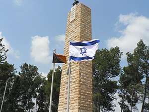 Doe Israeliese vlag langs die vlag van die Israeliese Ingenieurskorps (Geil ha-Handasá ha-Jisra'elí) by die Heldepad-Monument (Andartát Déreg ha-Ghwoerá)