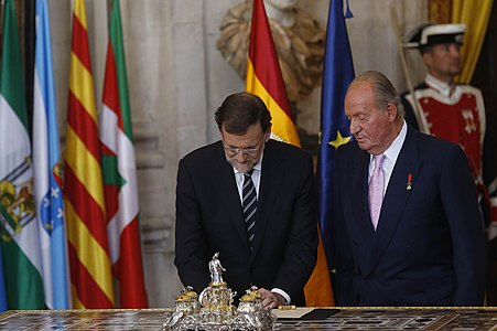 Joan Carles I junt amb el president de Govern Mariano Rajoy, mentre aquest últim ratifica la Llei orgànica d'abdicació (18 de juny de 2014)