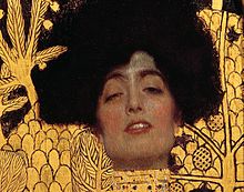 Gros plan sur le visage d'Adele Bloch-Bauer, modèle du tableau Judith et Holopherne (Klimt) (1901). Elle a les yeux mi-clos et les lèvres entrouvertes.