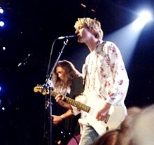 Una fotografia a colori di due membri della band Nirvana in concerto