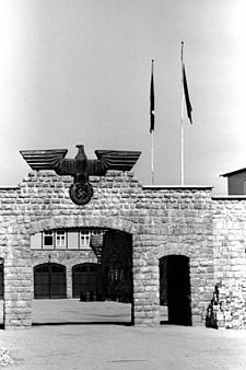 Gerbang batu dengan bagian atasnya dihias dengan sebuah patung elang berbahan metal berukuran besar gate yang memegang sebuah swastika; pada bagian belakang gerbang tersebut, tampak sebuah bangunan dengan dua gerbang garasi