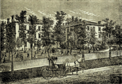 Black and white photo of a school building with trees, a horse and buggy in the foreground