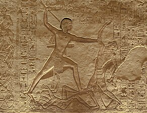 Faraonul egiptean Ramses al II-lea ucide un inamic în timp ce el îl calcă pe altul în bătălia de la Kadesh din 1274 î.Hr - Frescă cu hieroglife de la Abu Simbel.