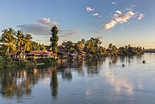 Mekong bank with stilt dwellings and clouds at golden hour in Don Det Laos.jpg