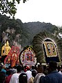 Icons carried in procession during Thaipusam at Batu Caves. Also seen in the background is the 42.7 m high golden statue of Lord Murugan.]]