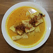 Laksan Palembang, mirip pempek disajikan dengan kuah kental berbahan santan, dan ditaburi bawang merah goreng