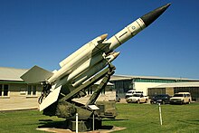Photo shows a white surface-to-air missile in a museum setting.