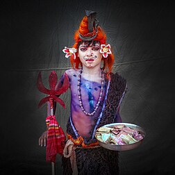 Menino vestido como Xiva, com trishula, colar de rosário e serpente, atributos típicos desta deidade hinduísta. Xiva é o Ser Supremo no xivaísmo, uma das principais tradições do hinduísmo. Xiva é conhecido como O Destruidor na trimúrti, a trindade hindu que também inclui Brama e Vixnu. (definição 3 455 × 3 455)