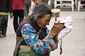 Một phụ nữ Tây Tạng lớn tuổi với một bánh xe cầu nguyện