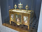Louis XVI style commode of Madame du Barry; by Martin Carlin (attribution); 1772; oak base veneered with pearwood, rosewood and amaranth, soft-paste Sèvres porcelain, bronze gilt, white marble; 87 x 119 cm; Louvre[62]