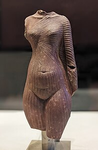 Corps de femme, peut-être de la reine Néfertiti. Quartzite rouge[90] Musée du Louvre