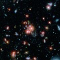Gugusan galaksi SpARCS1049 diambil oleh Spitzer dan Teleskop Luar Angkasa Hubble.[8]