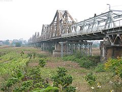 El Puente Long Biên visto desde una isla rural mirando hacia el centro de la ciudad.