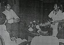 Four men seated around a small, round table