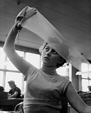 Kontroll av nylonstrumpor vid Malmö Strumpfabrik 1954. En kvinna håller upp en strumpa mot ljuset för att undersöka kvaliteten.