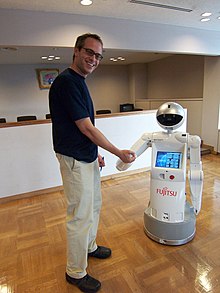 A man is shaking hands with a robot