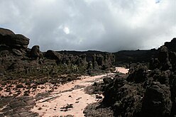 Formações rochosas ruiniformes e depósito de areia