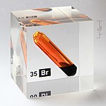 A vial of برم in an acrylic cube