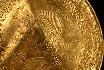 Guldmedaljong från Vindelevskatten (400-talet e.Kr.), från höger delvis ristad med runinskriften ᛉᛁᚹᛟᛞᚾᚨᛊᚹᛖ[ᚱ]ᚨᛉ (iswodnaswe[r]aʀ, möjligen "är Odens man").